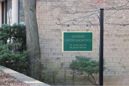 Sign for danoff orthodontics on a pole outside of office